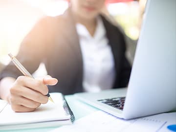 Person taking notes on laptop