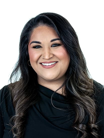 Smiling woman with long, wavy dark hair, wearing a black top