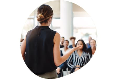 Woman presenting in front of seated crowd