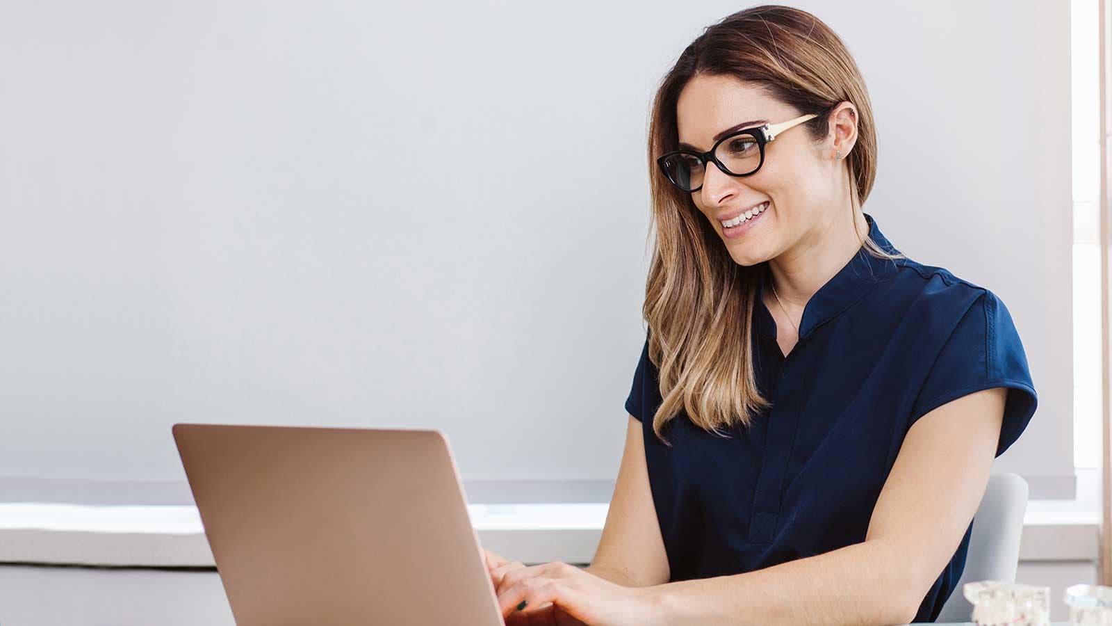 Lady dentist exploring Denplan benefits on laptop