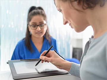 Patient filling in form on a tablet at dentist